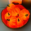 A woven basket filled with glowing orange LED pumpkins used as a decorative night light.