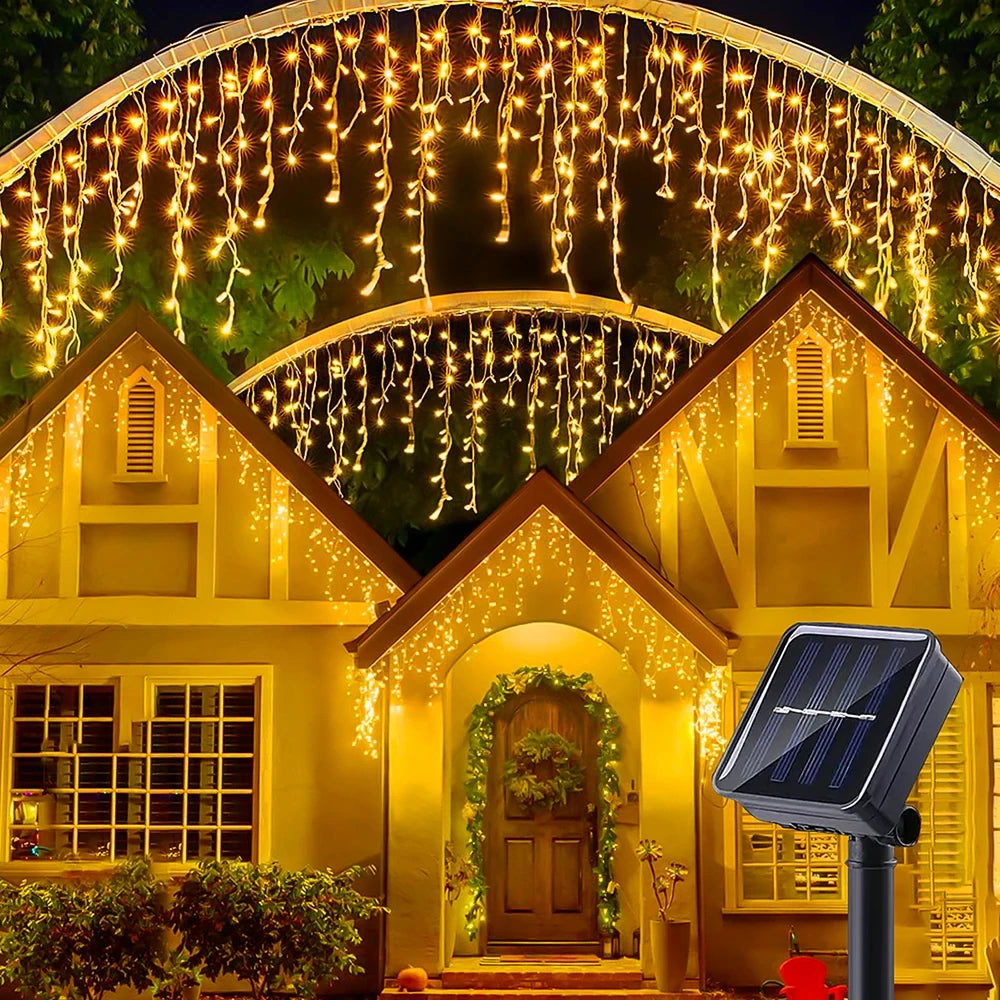 A house facade decorated with warm yellow string lights resembling icicles and a solar panel.