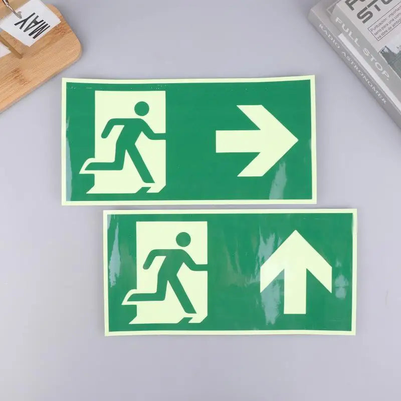 Two photoluminescent emergency exit signs, one showing a running figure and an arrow pointing right, and another showing a ru