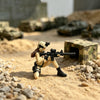 A female rifleman desktop figurine in tactical gear is posed on sandy terrain with military equipment in the background.