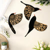 A set of three vintage wooden bird wall decorations featuring intricate patterns in black and tan on a white background.