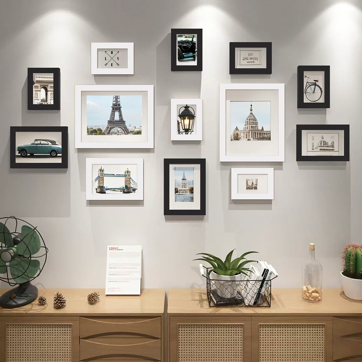 A collection of various sized wooden picture frames displayed on a light gray wall.