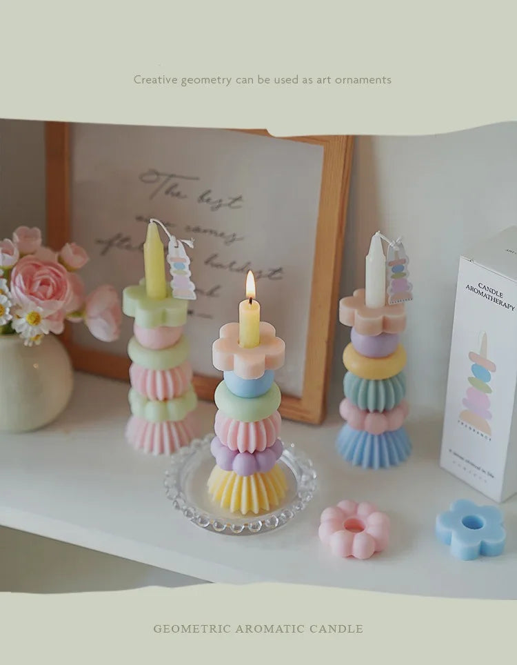 Geometric aromatic candle in pastel colors with a wick displayed on a glass plate.