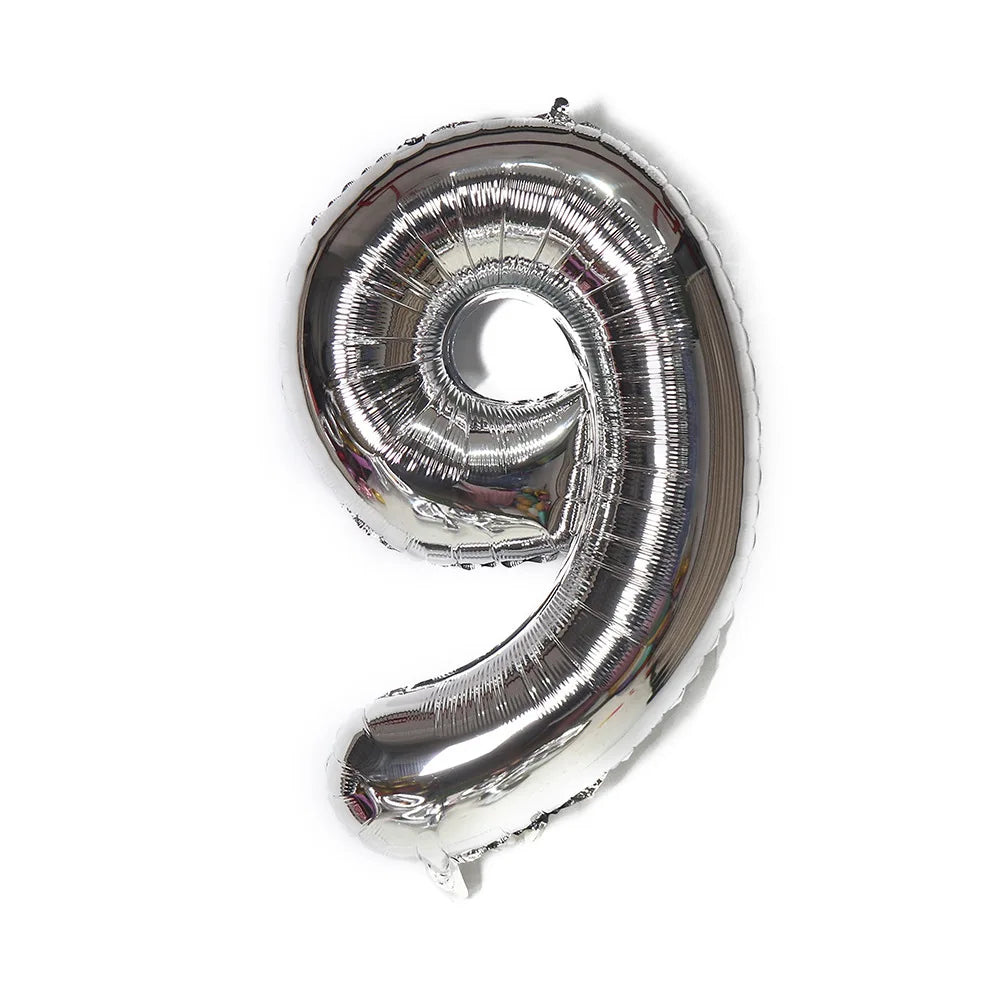 A metallic silver foil balloon shaped like the number nine.