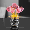 A decorative crystal rose flower arrangement with pink and clear glass petals on a gold stand.