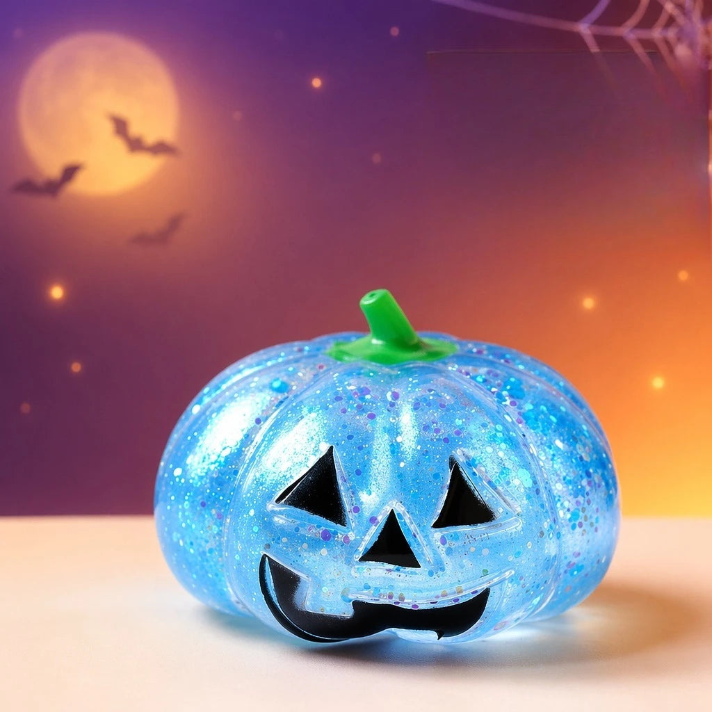 A glowing blue Halloween pumpkin stress ball with a carved face sits on a white surface against a purple and orange backgroun
