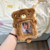 A brown fluffy plush photocard holder with a clear window displaying a picture of a person.
