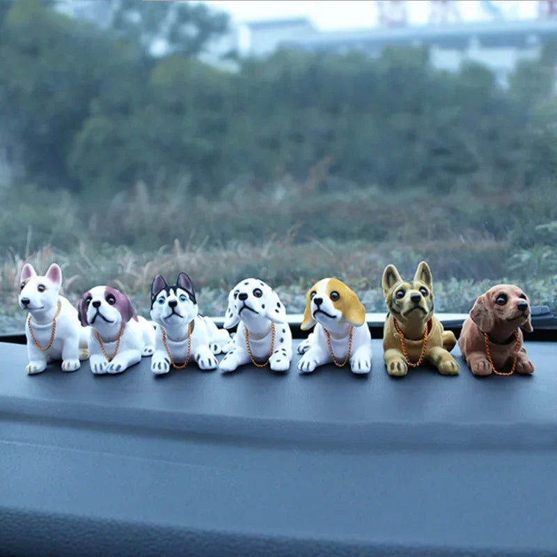 A row of eight small dog figurines, each wearing a beaded collar, lined up on a gray surface.