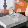 A silver and white molecular sculpture desk decor featuring interconnected spheres on a gray box.