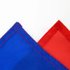 A close-up view of a vibrant blue fabric piece with red stitching and a red fabric piece against a white background.