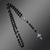 A black beaded rosary necklace featuring a vintage cross and Virgin Mary pendant.