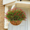A vibrant artificial lavender plastic wreath with bright red spikes hangs on a white door frame.