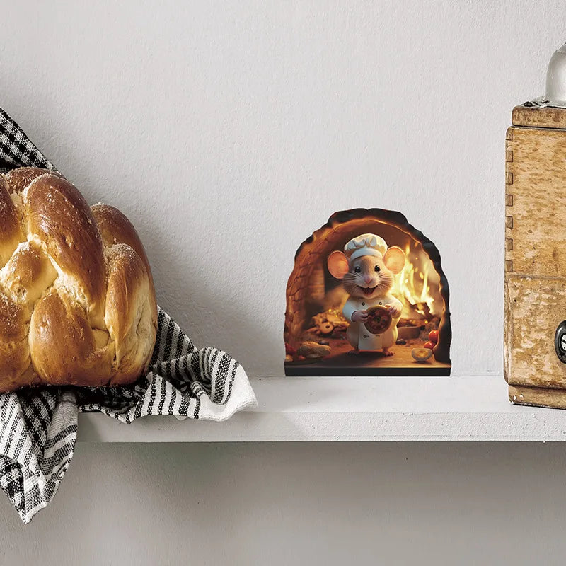 A cute mouse figurine wearing a chef hat is displayed in a hollowed-out log on a white shelf.
