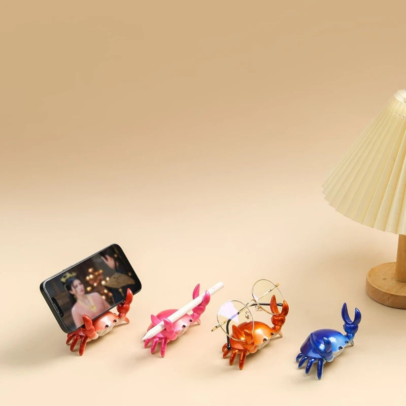 A set of crab-shaped desk organizers made of resin, including holders for a pen, phone, and other small items.