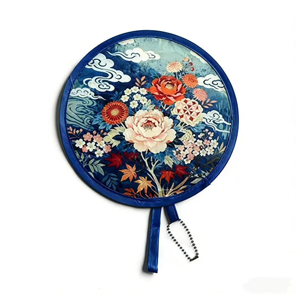 A round, blue fabric fan featuring a floral and cloud design.