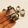A hand holds a vintage ceramic miniature lantern with a glass bulb and brass-colored metalwork.