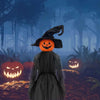 A spooky witch figure in a dark cloak stands before several glowing jack-o'-lanterns in a foggy forest setting.