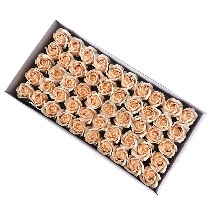 A box filled with numerous artificial rose flower heads in a light beige or peach color.