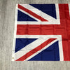 A folded United Kingdom national flag displayed on a gray textured surface.
