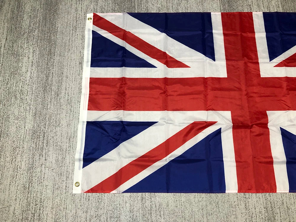 A folded United Kingdom national flag displayed on a gray textured surface.