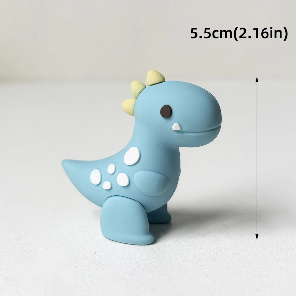 Topper de pastel de dinosaurio azul claro con una pequeña cabeza de púas amarillas y manchas blancas.