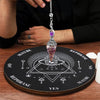A crystal pendulum set resting on a wooden divination board with various symbols and text.