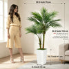 A woman stands next to a large artificial areca palm tree in a white pot, showcasing the plant's height and scale.