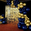 A balloon arch display featuring gold and navy blue balloons against a textured gold background.