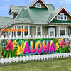 A tropical floral banner featuring large colorful flowers and green leaves displayed in front of a house.