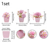 A set of three pink ceramic pots with simulated miniature flowers for home decor.