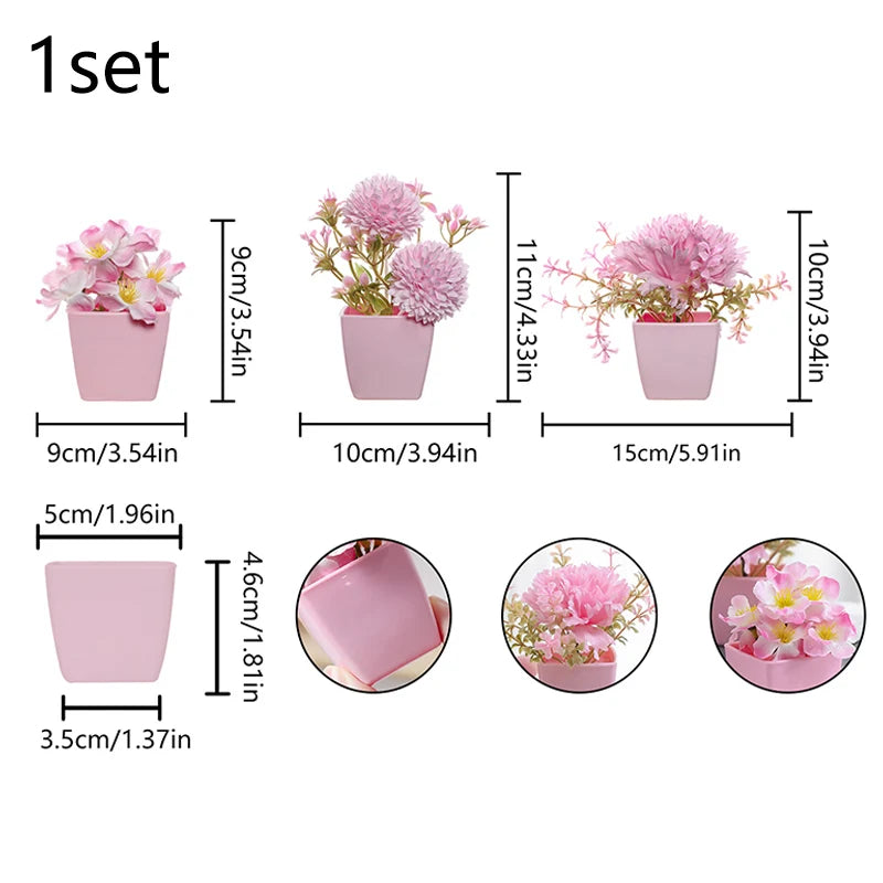 A set of three pink ceramic pots with simulated miniature flowers for home decor.