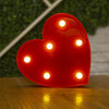 A bright red heart-shaped light fixture with multiple warm white LED lights illuminating the surface.
