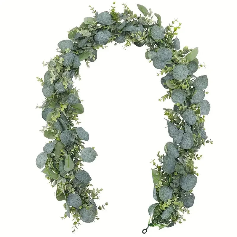 A green and gray artificial eucalyptus leaf garland forming an arch for home decor.