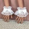Pair of white ruffled lace wrist cuffs with bowknot accents displayed on a hand.