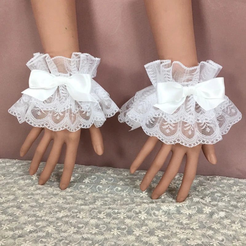 Pair of white ruffled lace wrist cuffs with bowknot accents displayed on a hand.