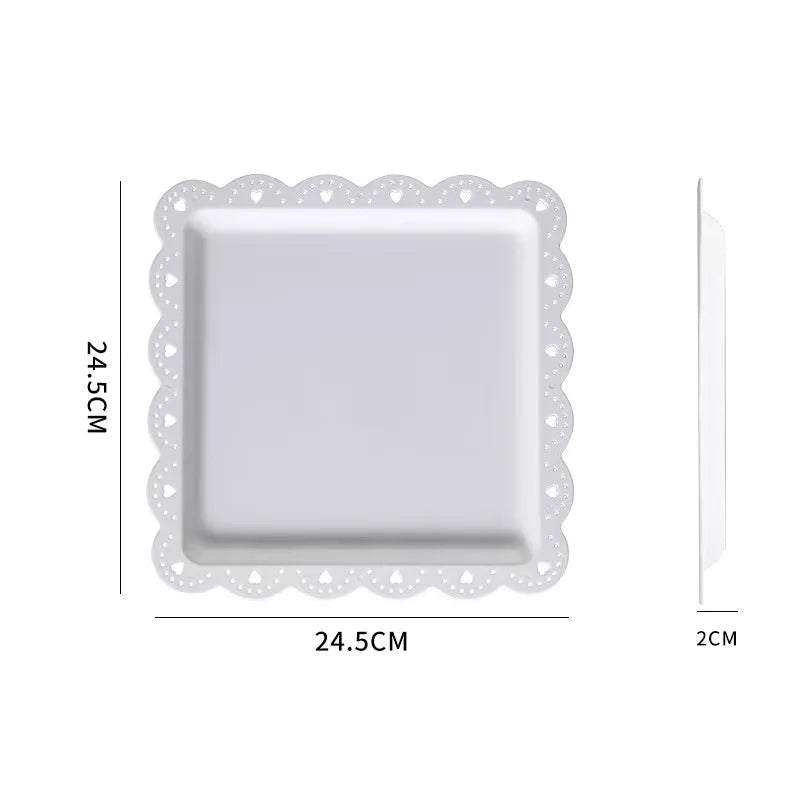 A white decorative food tray with a scalloped edge and a square serving dish.