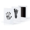 A set of three framed prints showing handprints and footprints on white paper.