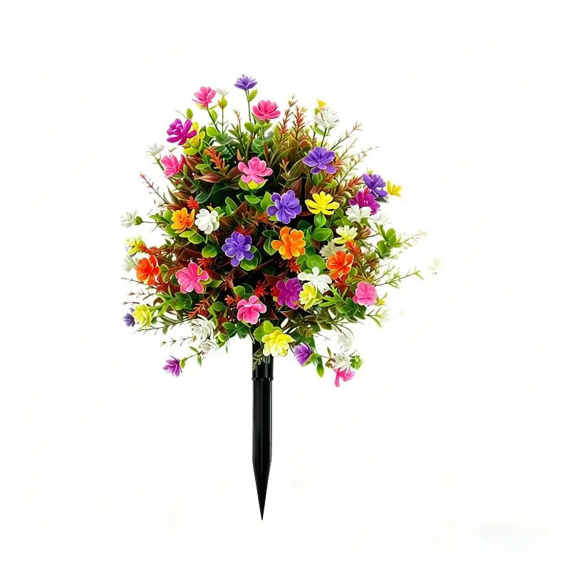 A bouquet of colorful artificial petunias in shades of pink, purple, orange, and yellow, arranged on a black stake.