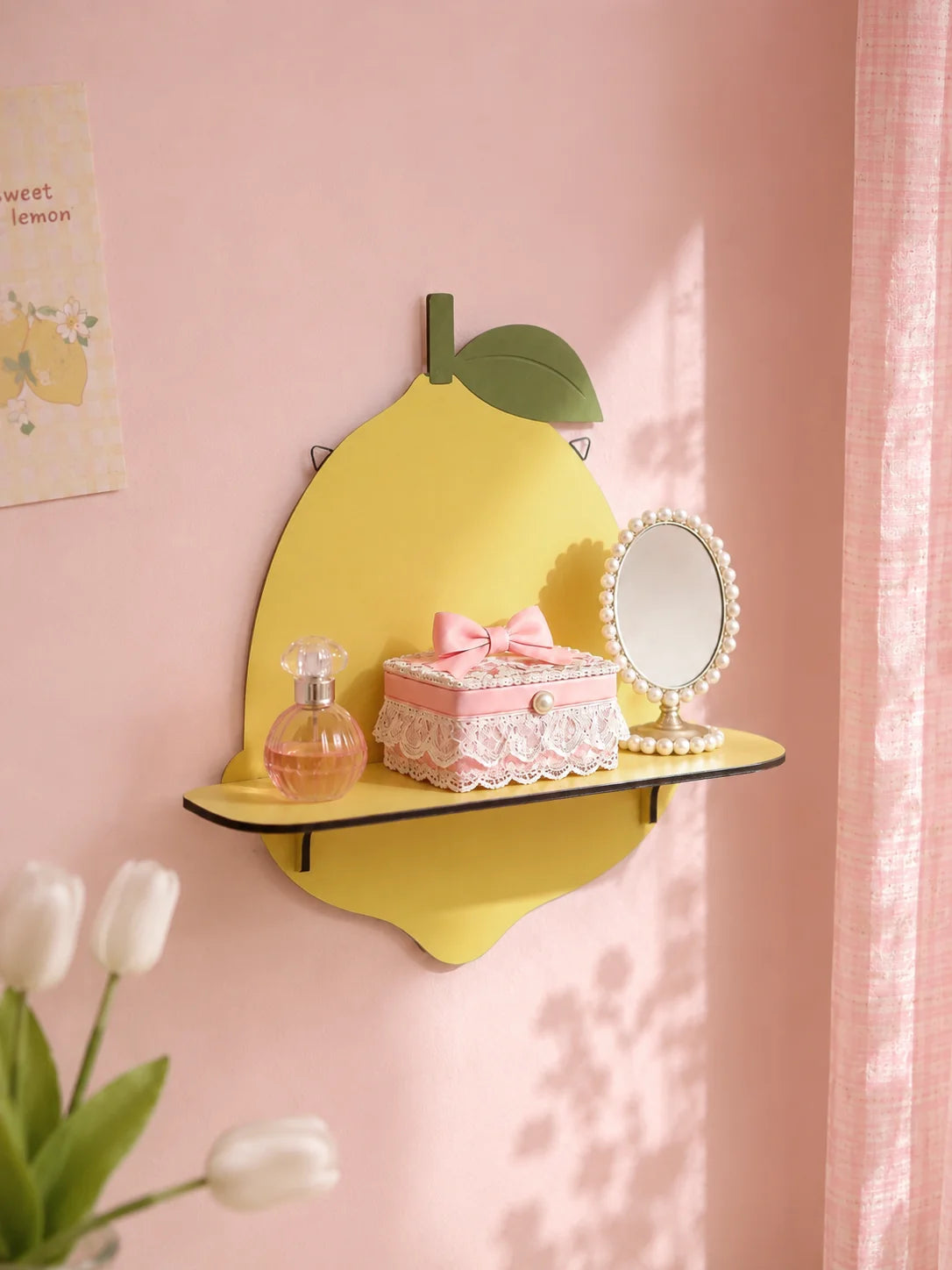 A yellow ceramic apple wall shelf featuring a pink box, perfume bottle, and a small mirror on a pink wall.