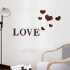 A wall decal featuring the word LOVE in large letters with small brown heart shapes floating above it.