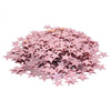 Confettis en acrylique rose avec des étincelles, dispersés sur un fond blanc