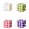 A set of two soy wax candles shaped like cubes in white and pink colors.