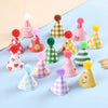 A collection of colorful mini birthday cake toppers featuring various patterns and pink, yellow, and green colors.