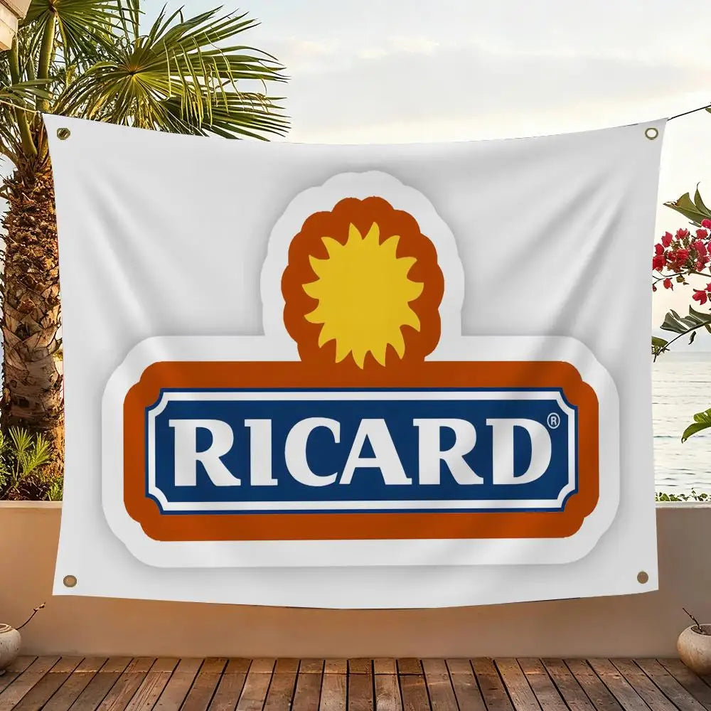 A white flag featuring a logo with an orange sun design and the word RICARD in blue text on an orange background.
