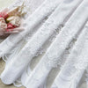White lace mesh sheer curtain with rod pocket displayed on a light surface.