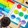 A child is interacting with a magnetic fraction learning board showing various colored and sized fractions.