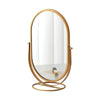 A round, gold-toned rotating oval vanity mirror with a thin frame.