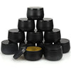 A stack of black metal candle tins with lids, including one open tin showing a gold interior.