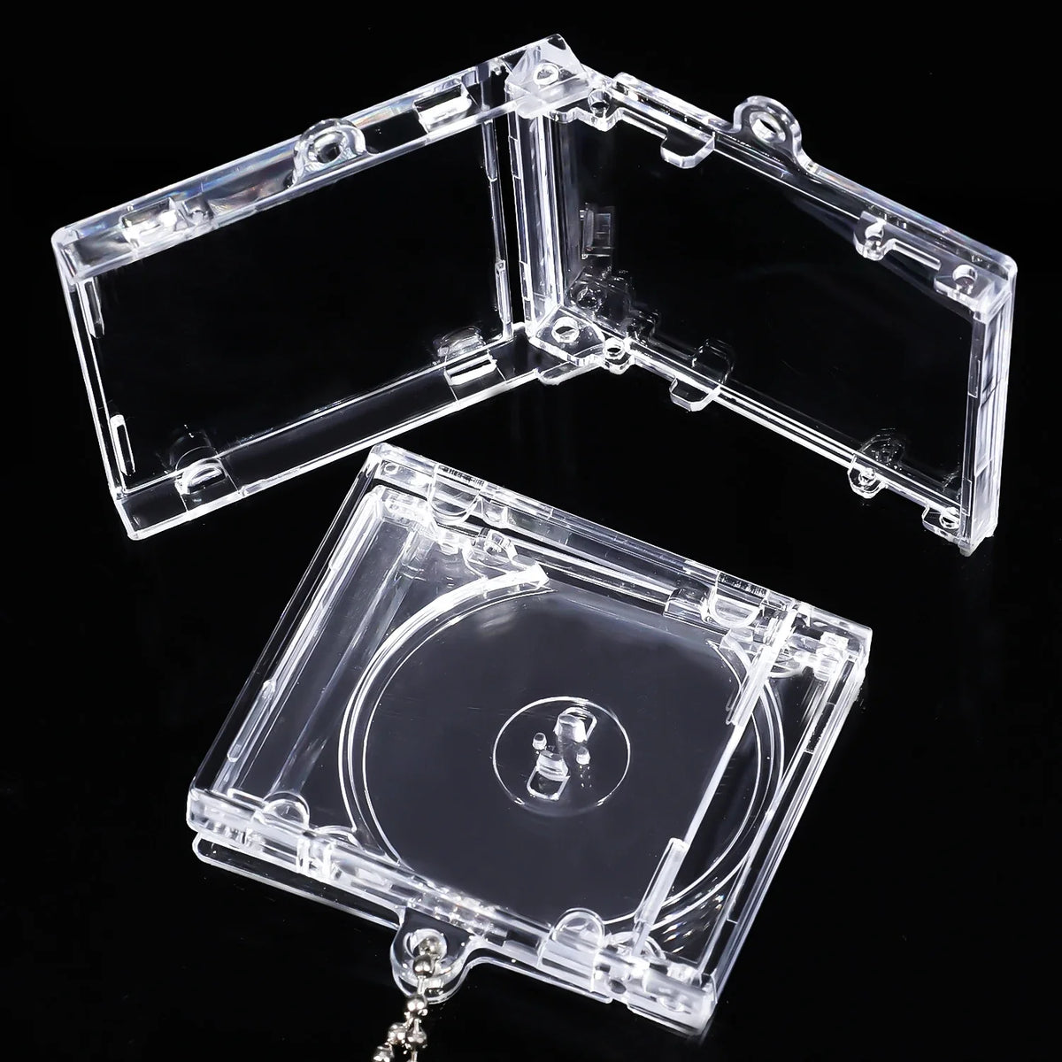 A clear plastic mini CD keychain is shown open, revealing a transparent disc and a chain attachment.