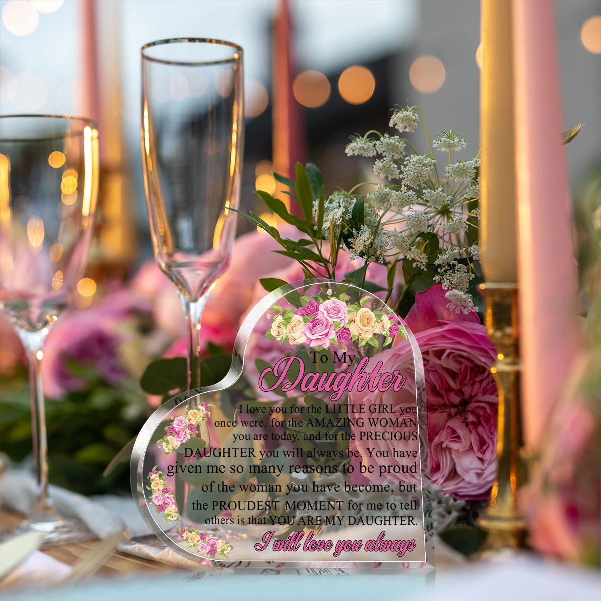 Herzförmige Acrylplatte mit eingraviertem Text inmitten von rosa und grünen Blumenarrangements.